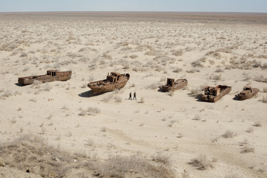Fishing boats stands in dried out Aral sea lake